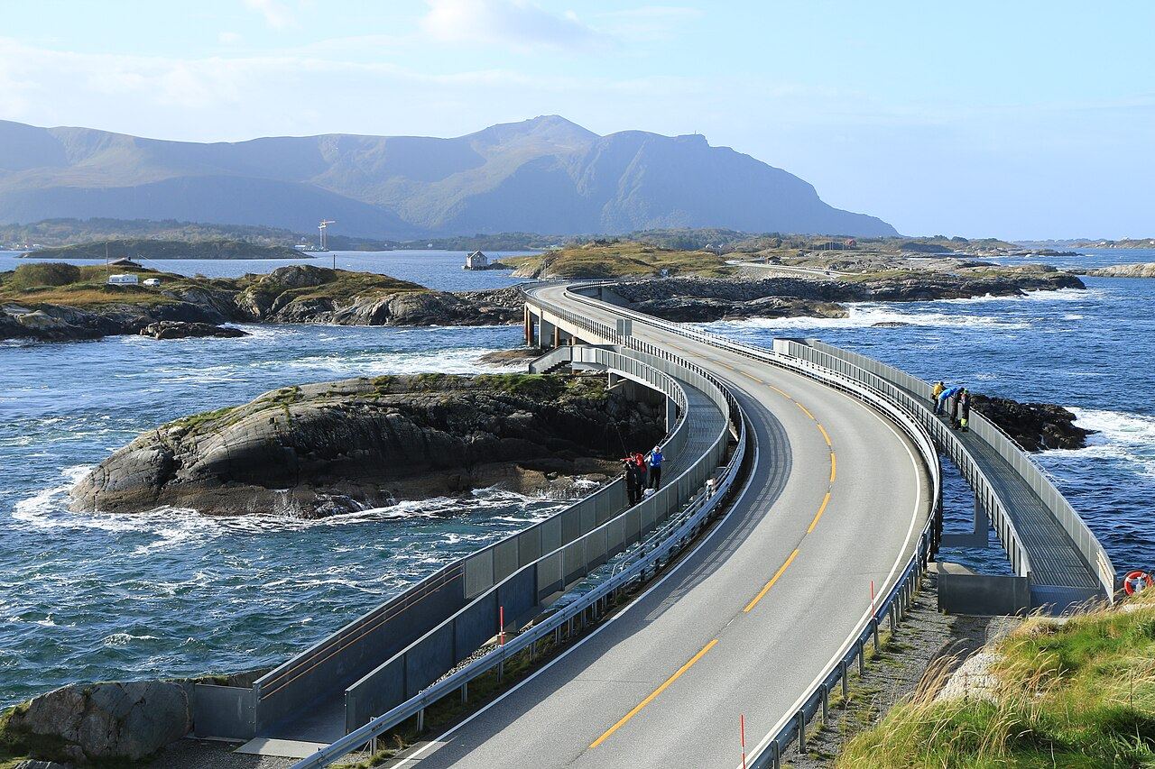 The Atlantic Road curving over a bridge between rocky islets, with surf and blue sea