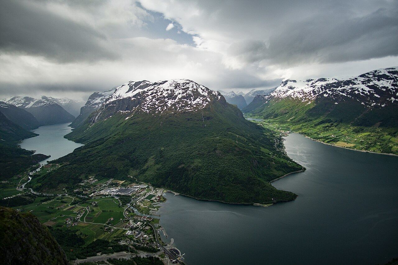 View from the top of Loen Skylift over a dark fjord wrapping around a snow-capped mountain